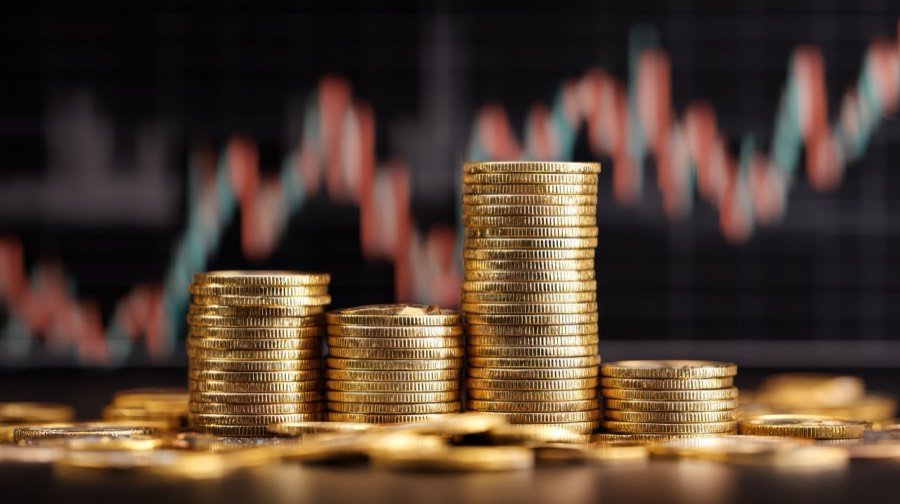 Coins stacked against a rising market chart